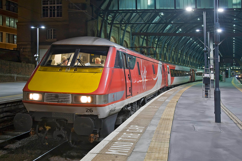 91126, GR 21.00 London King's Cross-Newcastle (1N34), London King's Cross station 
 The 1N34 21.00 departure to Newcastle still has over fifteen minutes before it is scheduled to depart but already two VTEC employees are in the cab preparing their paperwork; I wonder if one is undergoing some sort of driver training? 91126 will lead the train that should arrive at Newcastle half an hour or so after midnight. 
 Keywords: 91126 21.00 London King's Cross-Newcastle 1N34 London King's Cross station