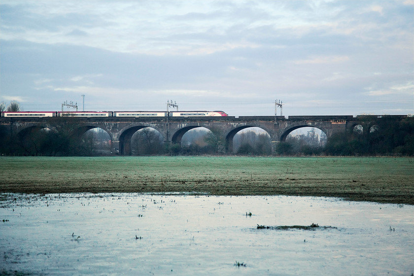 Class 390, VT 07.03 London Euston-Birmingham New Street (9G04), Haversham SP818425 
 Just after sunrise and an unidentified class 390 passes northbound over Haversham Viaduct with the 9G04 07.30 from London Euston to Birmingham New Street. The frozen ground in the foreground was as cold as it looked! By now, my feet were suffering as I had underestimated the temperature and only put one pair of socks on! 
 Keywords: Class 390 9G04 Haversham