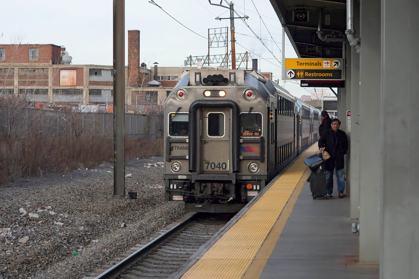 7040, 14.29 New York Penn-Jersey Avenue (3719), Newark International Airport station 
 One of NJ Transit Rail Operations' multi-level sets number 7040 arrives at Newark International Airport station. There are 643 of these coaches all built by Bombardier with the final set introduced two years ago in 2014. At the back of this 14.29 New York Penn to Jersey Avenue 3719 service would be a locomotive pushing the train; unfortunately I did not record which one was operating on this set. 
 Keywords: 7040 14.29 New York Penn-Jersey Avenue 3719 Newark International Airport station