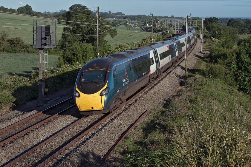 390114, VT 05.46 Wolverhampton-London Euston (1B02, 2E), Milton crossing 
 In lovely early morning light 390114 'City of Manchester' passes Milton crossing between Blisworth and Roade working the 05.46 Wolverhampton to Euston service. However, the bright spring sunshine belies the fact that there was a strong north-easterly wind blowing that caught me out finding me underdressed for the ocassion! 
 Keywords: 390114 05.46 Wolverhampton-London Euston 1B02 Milton crossing City of Manchester