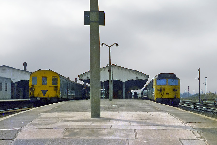 1111 & class 50, unidentified up workings, Westbury station 
 I seemed to take pictures from odd positions and angles as a youngster and this is one of them! Two trains side-by-side at Westbury station, to the left, is a Class 205 'Thumper' 1111. This was probably on a Portsmouth Harbour to Bristol Temple Meads working. To the right, a 'Hoover' Class 50 arrives with a London Paddington working. It is actually quite a good thing that it's a grey day with weak sunshine witnessed by the shadow of the mast in the foreground as if there had been blue skies, this particular spot would have been badly backlit! I replicated this view on a visit to Westbury in 2022, whilst the motive power is a little different essentially, the view is the same over forty-five years later, see.... https://www.ontheupfast.com/p/21936chg/30023905798/x11-164132-165136-gw-11-11-weymouth 
 Keywords: 1111 class 50 Westbury station