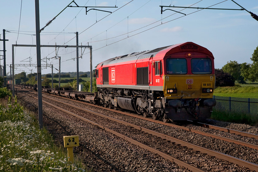 66027, 13.12 Trafford Park-London Gateway (4L56), Milton Malsor 
 At 62 miles from London Euston, Milton Malsor is a small village on the Northampton loop line just south of the town. 66027, looking good in its smart DB livery, leads the lightly loaded 4L56 13.12 Trafford Park to London Gateway Freightliner. Even though this was a lovely summer evening, it was a bit nippy with a keen wind blowing from the north west. 
 Keywords: 66027 13.12 Trafford Park-London Gateway Freightliner 4L56 Milton Malsor