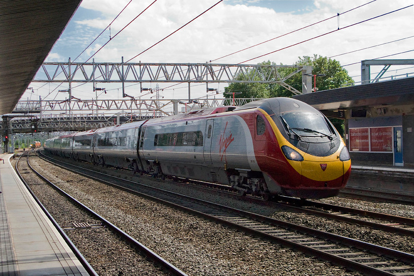 390132, VT 13.30 London Euston-Glasgow Central (1S69), Stafford station 
 390132 'City of Birmingham' passes through Stafford's centre road forming the 13.30 Euston to Glasgow Central. Usually, trains pass through Stafford at a fair speed but due to engineering works associated with re-signalling and track re-modelling taking place this one was travelling at a more modest pace. Indeed, a Colas liveried track machine can be seen in the distance associated with the said works. 
 Keywords: 390132 13.30 London Euston-Glasgow Central 1S69 Stafford station Virgin Pendolino