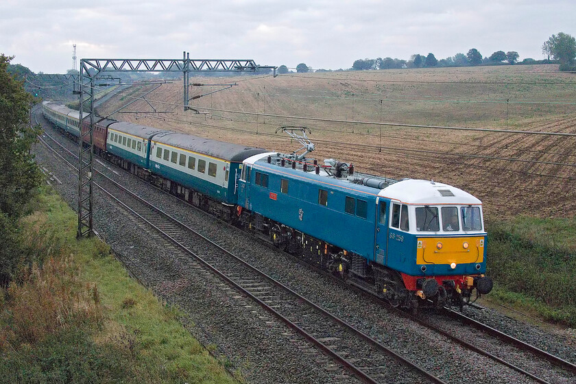 86259, outward leg of The Cumbrian Coast Express, 06.37 London Euston-Carlisle (1Z86, 16L), Milton crossing 
 There were some tantalising small holes in the cloud to the east but none allowed the sun to come through to give some much-needed light here at Milton crossing just north of Roade cutting. Hauling some of West Coast Railway's newly acquired compliant Mk. II stock 86259 'Les Ross/Peter Pan' heads north with the outward leg of The Cumbrian Coast Express that left London at 06.37 heading for Carlisle. On arrival at Carlisle, the Class 86 would hand over to Black 5 44871. Incidentally, 35508, the Mk. I support coach attached to the rear of the train had an alarming wheel flat knocking its way past me here in Northamptonshire doing nothing for it or the track. On arrival at Cranforth later in the day prior to the 1Z87 heading south, it was detached from the train. 
 Keywords: 86259 The Cumbrian Coast Express 06.37 London Euston-Carlisle 1Z86 Milton crossing Les Ross Peter Pan