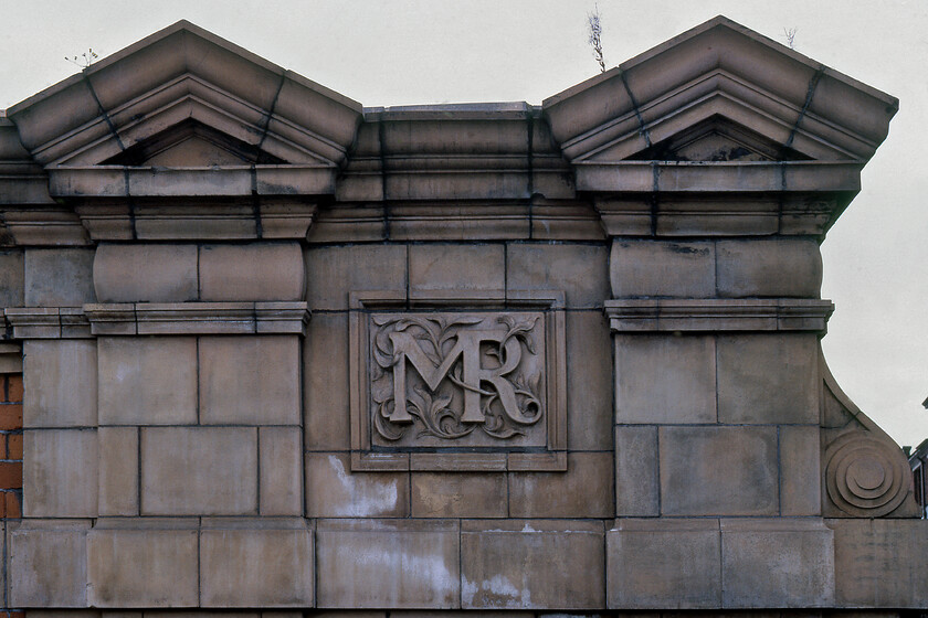 Midland Railway stone carved insignia, Leicester station 
 When a new station is constructed today signage is simply attached to or hung from the building. Back in Victorian times railway companies made far more bold statements about their structures as is the case here on the bridge parapet directly opposite Leicester's London Road station. Charles Trubshaw designed the Midland Railway's insignia as a large relief carved into the bridge's terracotta stonework detailing. 
 Keywords: Midland Railway stone carved insignia Leicester station