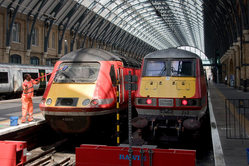 43208, GR 13.06 London King`s Cross-York (1N85, 11L) & 82212, GR 13.30 London King`s Cross-Edinburgh (1S19, 8L), London King`s Cross station 
 The windscreen of 43208 gets a wash to remove the summer detritus of dead flies at King's Cross. The HST will form the 13.06 1N85 'stopper' to York. A service that requires fast acceleration between stops to maintain quite tight timings is ably handled by an HST but these services will soon go to Azuma operation. Next to the HST 82212 will be at the rear of the 1S19 13.30 to Edinburgh. Within three weeks of this picture being taken, Azumas will start to operate these Anglo-Scottish services. For those who remember King's Cross station of old with its heavily pollution stained glazing and stonework, the environment of today is a massive improvement. 
 Keywords: 43208 13.06 London King`s Cross-York 1N85 82212 13.30 London King`s Cross-Edinburgh 1S19 London King`s Cross station