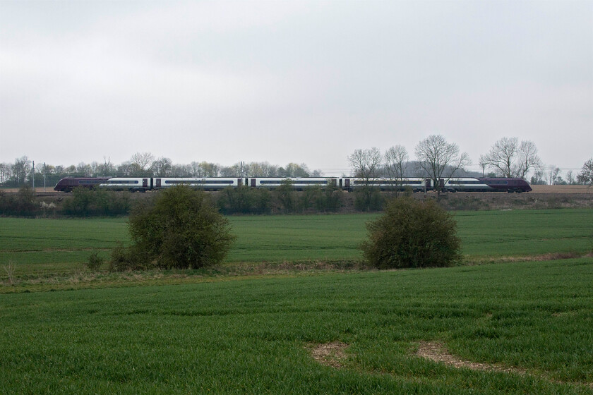 Class 180, EM 07.49 London St. Pancras-Corby (1M04, 1E), Wymington SP955638 
 Taken across the fields at Wymington one of EMR's recently acquired Class 180s heads north. It is working the 07.49 St. Pancras to Corby 1M04 service. After what seemed to be days of glorious weather with frosty but bright mornings this day being the one I chose to visit the MML was incredibly dull with a biting north-easterly wind blowing. The following day of course the fantastic spring weather returned as I did to work! 
 Keywords: Class 180 07.49 London St. Pancras-Corby 1M04 Wymington SP955638 EMR East Midlands Railway