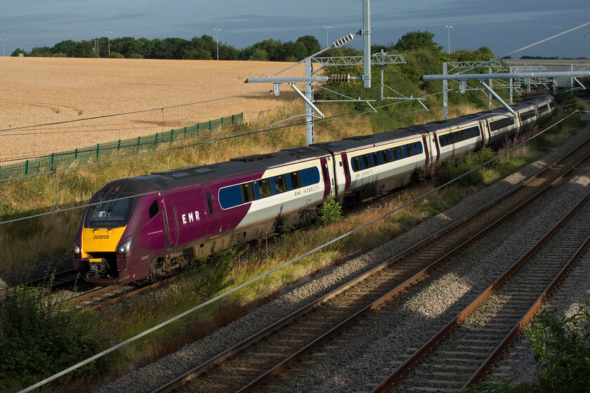 222023, EM 06.12 Nottingham-London St. Pancras (1B10, 1L), Irchester SP927667 
 With the sun about to disappear behind an otherwise cloudy skyscape (as seen in the background), EMR's 222023 heads south working the 06.12 Nottingham to St. Pancras service. This view is taken from a replacement footbridge near the village of Irchester. However, as it is a replacement structure, installed as part of the line's electrification, it has the antisuicide parapets, therefore, a step ladder is required to gain this view. 
 Keywords: 222023 06.12 Nottingham-London St. Pancras 1B10 Irchester SP927667 EMR Meridian