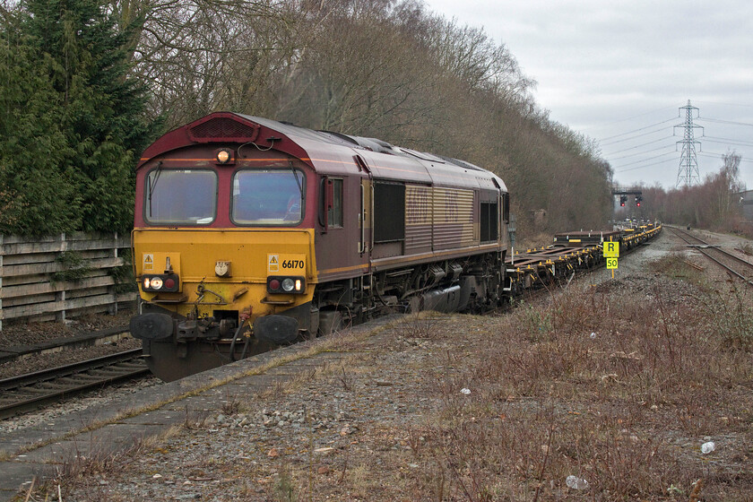 66170, 09.33 Bescot Yard-Scunthorpe BSC (6Z82, 46L), Water Orton station 
 In its as-built condition, EWS liveried and branded 66170 gets the 6Z82 09.33 Bescot to Scunthorpe up to speed after being held for some time prior to joining the mainline at Water Orton West Junction located just beyond the colour lights near the overhead transmission pylon. Andy and I have seen and photographed this particular Class 66 before on two previous forrays in very different locations, firstly in the south https://www.ontheupfast.com/p/21936chg/24848714604/x66170-66133-10-17-scunthorpe-trent and secondly in East Yorkshire https://www.ontheupfast.com/p/21936chg/24425940804/x66170-16-25-hedon-road-sidings-masborough and none of these times were in the sunshine! 
 Keywords: 66170 09.33 Bescot Yard-Scunthorpe BSC 6Z82 Water Orton station