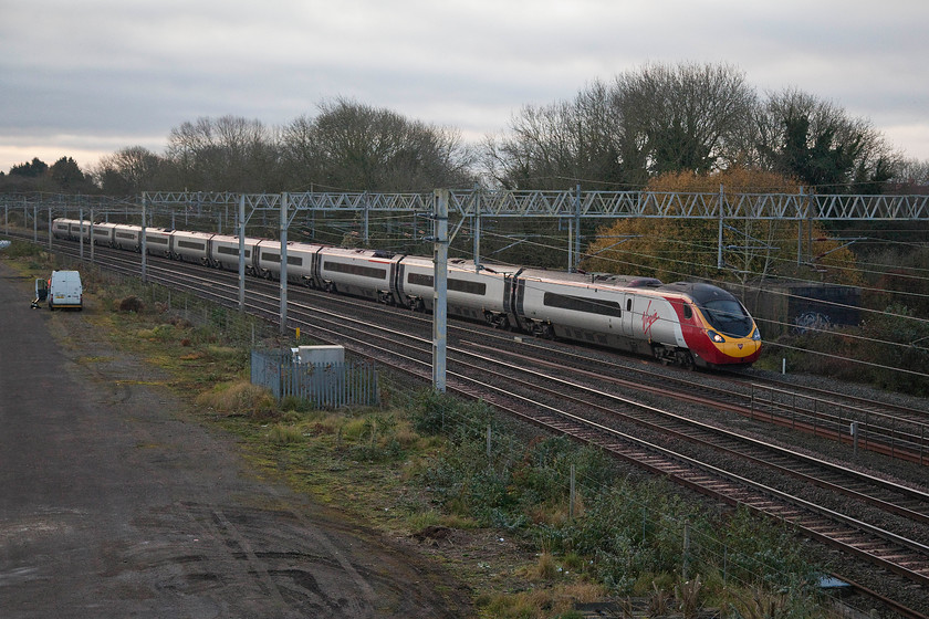 390135, VT 07.20 London Euston-Manchester Piccadilly (1H09, 4L), site of Roade station 
 Asking a fair bit of the camera in the gloom of a cloudy early November morning but it still amanges to capture 390135 'City of Lancaster' passing the site of Roade station working the 07.20 London Euston to Manchester Piccadilly. The old Roade signal box was located approximately behind coaches A and B. 
 Keywords: 390135 07.20 London Euston-Manchester Piccadilly 1H09 site of Roade station