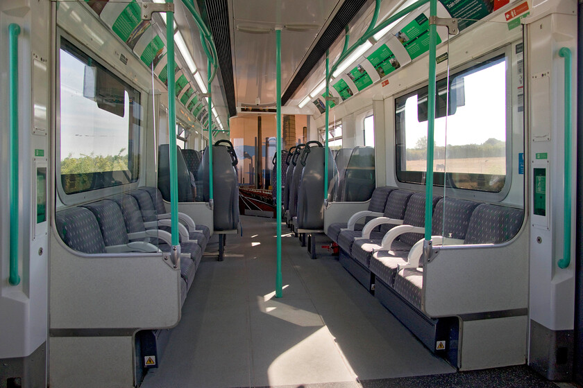 Interior, 230004, LN 09.17 Bletchley-Bedford (2S09, 1E), between Bow Brickhill & Woburn Sands 
 The interior of 230004 as we travel along the Marston Vale route on the approach to Woburn Sands (of safari park fame). The former London Underground D78 stock has been converted (or repurposed as Vivarail prefer to put it in a modern vernacular!) with the interiors looking very modern and functional. Whilst the side facing seating is essentially the same as to its as built configuration the two-plus-two seating further down is different with the toilet pod definitely never a feature from 1980 when the D78s were built Metro-Cammell in Birmingham! in 1980! In a nod to the past industrial heritage of the line's route note the brick work chimney vinyls applied to the toilet pod, something that the area was once famous for all of which have now been demolished with the wholesale closure of the once thriving industry. 
 Keywords: Interior 230004, LN 09.17 Bletchley-Bedford 2S09 Bow Brickhill & Woburn Sands