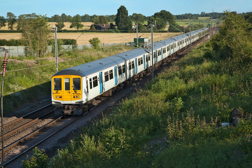 319219, 319214 & 319441, LN 17.53 London Euston-Northampton (2N51, 3L), Milton Malsor SP738560 
 London Northwestern retain a small number of ex. Thameslink class 319 to supplement their services during peak commuter times. Here, 319219, 319214 and 319441 approach Northampton with the 17.53 from Euston, a journey that has taken seventy minutes. This location is just near to the village of Milton Malsor and at a spot that has been opened up by Network Rail's vegetation removal strategy. Previously, this shot would have been impossible due to the rampant tree growth on the embankment, however, as can be seen, they will need to attend to the site again given the re-growth already in evidence. 
 Keywords: 319219, 319214 319441 17.53 London Euston-Northampton 2N51 Milton Malsor SP738560