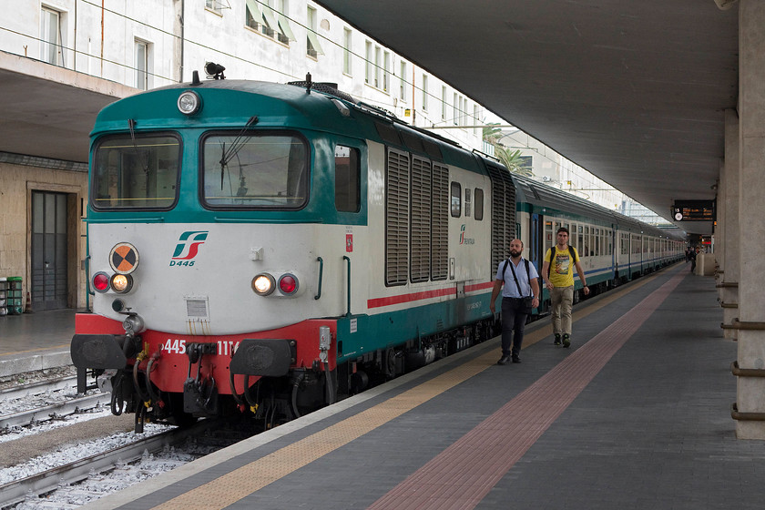 445.1116, 17.55 Florence SMN-Borgo SL (11993), Florence SMN-Station 
 The driver and his assistant walk purposely down to their locomotive, 445.1116. Notice that there is no driver's door on this side necessitating them to climb to track level, walk around the front of the locomotive and climb in the door on the other side. The diesel is about to work the 17.55 Florence SNM to Borgo SL commuter service. It made a very dramatic departure a few minutes after this picture was taken making a heck of a racket! 
 Keywords: 445.1116 17.55 Florence SMN-Borgo SL 11993 Florence SMN-Station