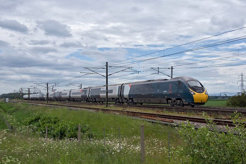 390112, VT 08.43 London Euston-Edinburgh Waverley (9S54, RT), Mossband M6 bridge NY347654 
 Under a vast skyscape and with the northern fells of the Lake District in the background 390112 speeds northwards working the 9S54 08.43 Euston to Edinburgh Waverley Avanti service. The photograph is taken from a small access road that runs under the M6 motorway located immediately behind where I am standing. 
 Keywords: 390112 08.43 London Euston-Edinburgh Waverley 9S54 Mossband M6 bridge NY347654.