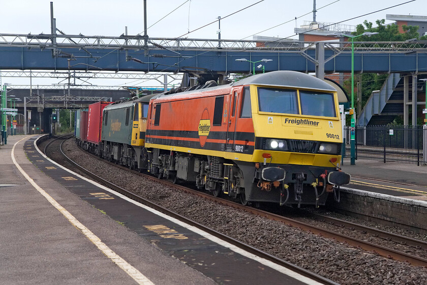 90012 & 90041, 02.57 Felixstowe North-Garston (4M45, 49E), Wolverton station 
 The 4M45 02.57 Felixstowe to Garston Freightliner service sweeps through Wolverton station. It is being led by 90012 and 90041 that wear the new and old versions of Freightliner's (Genesee & Wyoming) liveries. Back in the autumn of 2018 I travelled with 90012 on the Great Anglia route from Diss to Norwich. 
 Keywords: 90041 90012 02.57 Felixstowe North-Garston 4M45 Wolverton station Freightliner