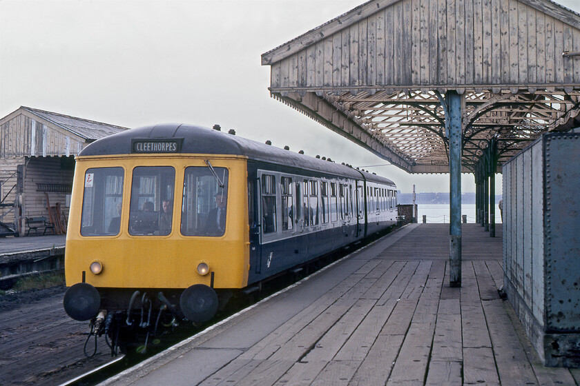 Class 114 DMU, 15.07 New Holland Pier-Cleethorpes, New Holland Pier 
 Having arrived at New Holland Pier with a service from Cleethorpes, the train crew have already changed ends and are readying their Class 114 DMU for departure as the 15.07 back to Cleethorpes. The antiquated nature of the station structure on the pier located well out into the Humber estuary is clear to see in this photograph but amazingly, today the buildings still stand having been repainted in recent years even if totally dwarfed by a huge elevated grain conveyor and a number of cranes 
 Keywords: Class 114 DMU 15.07 New Holland Pier-Cleethorpes New Holland Pier First generation DMU