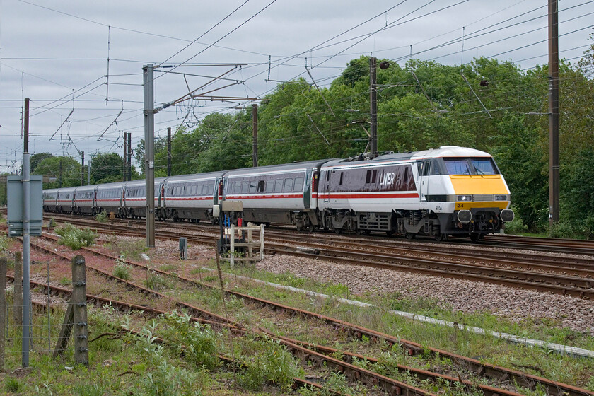 91124, GR 10.03 London King's Cross-Leeds (1D09, 1L), Tallington Dowmac 
 Still looking very smart in its cleverly done InterCity Executive/LNER cross-livery 91124 passes the Dowmac concrete factory just north of Tallington. The Class 91 is working the 10.03 King's Cross to Leeds service continuing on its thirty-four years of service on this route. 
 Keywords: 91124 10.03 London King's Cross-Leeds 1D09 Tallington Dowmac IC225