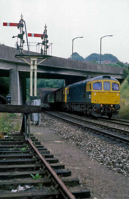 33015 & 33043, 09.20 Brighton-Exeter St. David's (1V61), west of Salisbury tunnel 
 It was a tradition that services between Brighton and Exeter were double-headed throughout. There was always a shout from the spotters on platform ends of 'double header' when one of these services approached! 33015 leads 33043 on the 09.20 Brighton to Exeter St. David's 1V61 service on the approach to Salisbury with the train having just emerged from Salisbury's Fisherton tunnel. The train is passing under the A36 Churchill Way North inner relief road. Both of these locomotives have been scrapped with 33043 outliving 33015 by two years. The latter was condemned after a serious underframe fire whilst hauling a stone train near Tiverton Junction in July 1989. 
 Keywords: 33015 & 33043, 09.20 Brighton-Exeter St. David's (1V61), west of Salisbury tunnel Crompton