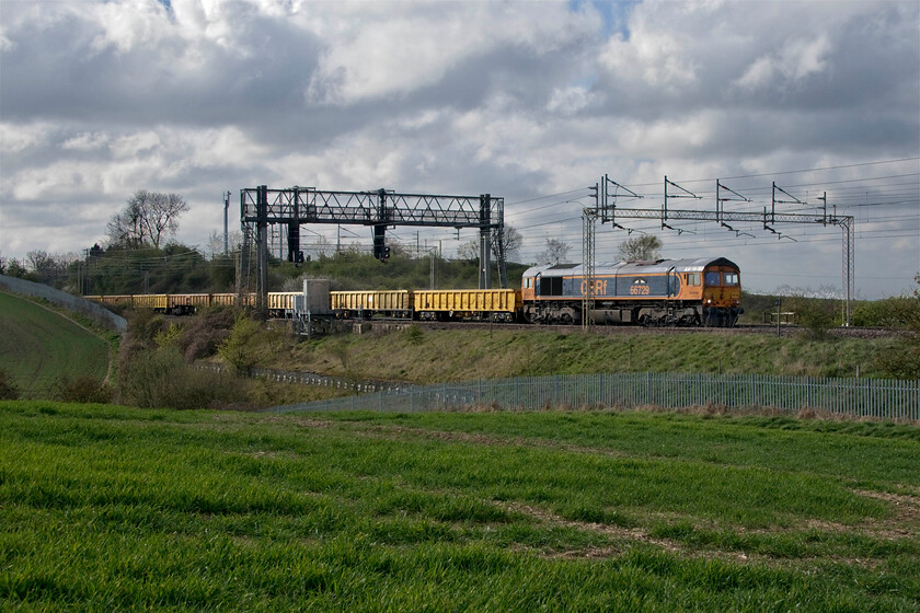 66729, 08.19 Hanslope Junction-Bescot Up Engineering sidings (6G54, 16L), between Roade & Ashton 
 66729 'Swanage Railway' leads the 6G54 to Bescot that was the first infrastructure working of the day seen between the villages of Roade and Ashton in south Northamptonshire. The train was made up of a rake of MLA and JNA ballast wagons and had been involved in work on the fast lines a short distance south of this location at Hanslope Junction. 
 Keywords: 66729 08.19 Hanslope Junction-Bescot Up Engineering sidings 6G54 between Roade & Ashton Swanage Railway GBRf