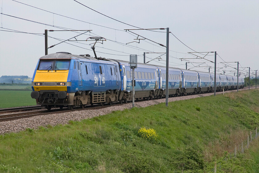 91125, GR 15.00 London King's Cross-Edinburgh Waverley (1S22), Frinkley Lane crossing SK906436 
 Whilst I am not a fan of Sky due to the activities of its owner Rupert Murdoch and refuse to have anything to do with any of his business interests where possible that includes the reading of any of his rags! However, I did want a photograph of the Sky 1HD 225 set on the ECML. Set BN25 emerged in this striking livery in the autumn of last year with 91125 being the lead locomotive. Working the 15.00 King's Cross to Edinburgh service the set is seen passing Frinkley Lane crossing just north of Grantham. 
 Keywords: 91125 15.00 London King's Cross-Edinburgh Waverley 1S22 Frinkley Lane crossing SK906436