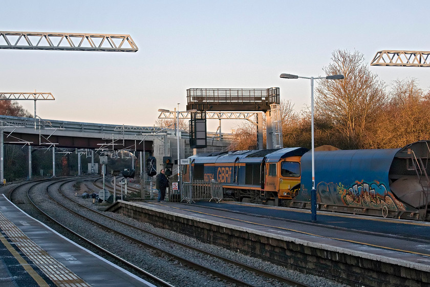 66764, 12.18 Colnbrook-Bardon Hill (6M54), Wellingborough station 
 Not a great picture of 66764 passing through Wellingborough station but as it was a photographic cop I have included it. It is leading the 6M54 12.18 Colnbrook to Bardon Hill empty stone train. This image shows clearly the new quadruple track layout leading northwards towards Kettering passing underneath the newly built and recently opened Roundhouse Way road bridge. This road provided access to the huge new Stanton Cross housing development to the east of the town and also to the former steam shed (15A and 15B) that is being redeveloped into a supermarket. 
 Keywords: 66764 12.18 Colnbrook-Bardon Hill 6M54 Wellingborough station