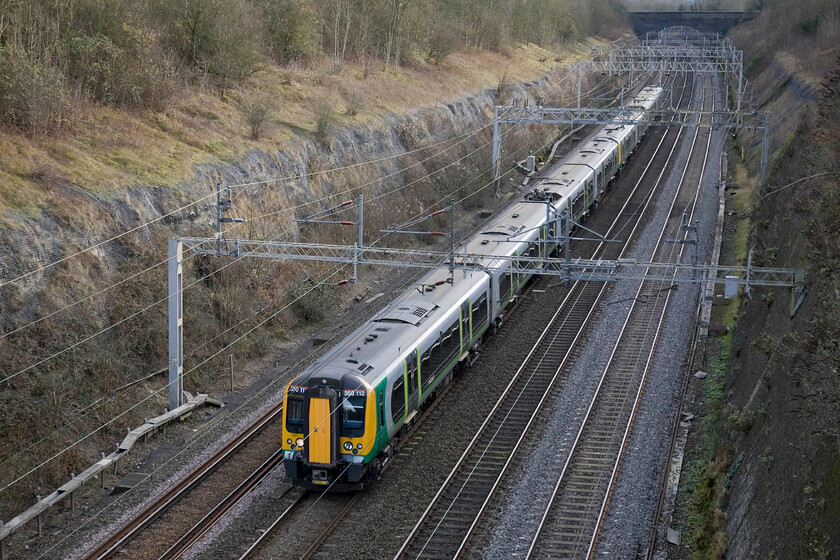 350128 & 350111, LM 11.24 London Euston-Birmingham New Street & Crewe (2Y18), Roade cutting 
 350128 and 350111 work the 11.24 London Euston to Birmingham and Crewe service through Roade cutting. However, both units will not end up in Crew with the train being split on arrival at New Street with just 350128 working forward. This will leave another southbound unit from Crewe to join to the rear of 35011 to then return to London. However, all has not been going well with Lonon Mildand's split trains with delays playing havoc with the logistics so I wonder if this service pattern will return again in the 2015/16 timetable? 
 Keywords: 350128 350111 11.24 London Euston-Birmingham New Street Crewe 2Y18 Roade cutting London Midland Desiro