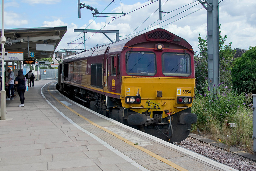 66154, 08.50 Purfleet-Acton (7V39), Willesden Junction station 
 Whilst waiting for our connecting train at Willesden Junction 66154 eased around the sharp curve from the east with the 7V39 08.50 Purfleet to Acton stone train. Here at Willesden the train was not far off its destination just having to pass Acton Wells Junction signal box (a remarkable survivor) and then head west to Acton yard adjacent to the GWML. 
 Keywords: 66154 08.50 Purfleet-Acton 7V39 Willesden Junction station