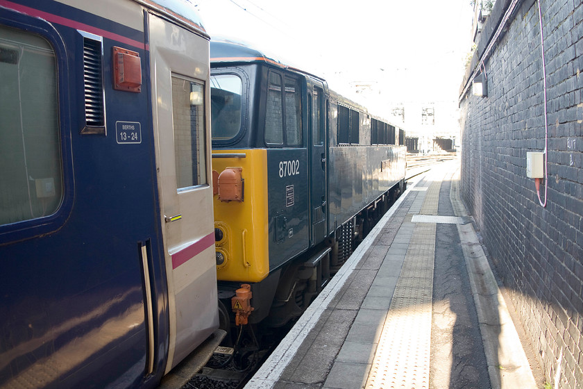 87002, CS 08.27 London Euston-Wembley sleeper ECS (5M11), London Euston station 
 87002 'Royal Sovereign' sits at the head of the 08.27 Euston to Wembley sleeper ECS stock working. Euston's platform one at the country end is less of a platform and more of a walkway! This makes photography somewhat of a challenge especially with the tricky lighting of a winter's morning! 
 Keywords: 87002 08.27 London Euston-Wembley sleeper ECS 5M11 London Euston station