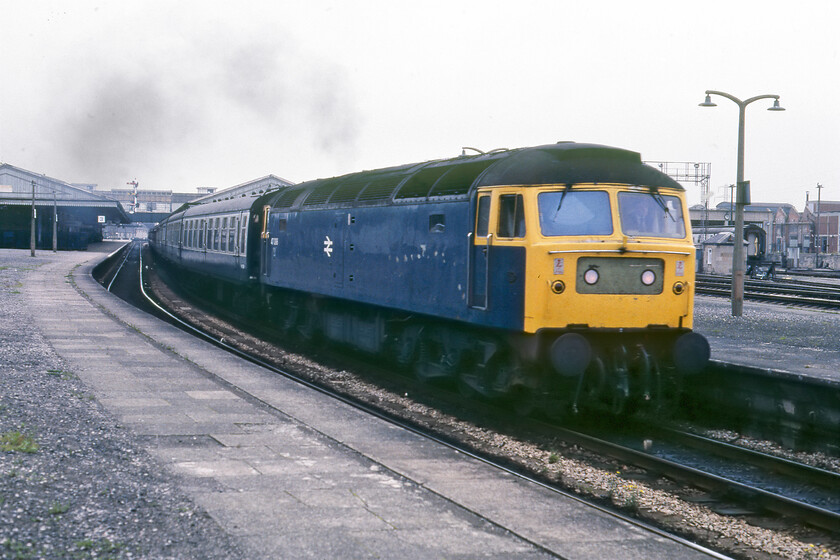 47098, unidentified down working, Newton Abbot station 
 47098 makes a typical smokey departure from Newton Abbot leading an unidentified down service that I suspect was heading on to Cornwall rather than to Paignton due to it being on the down main rather than the relief. This photograph has had a lot of Photoshop treatment as it was rescued from the reject box due to chronic under-exposure. If anybody can advise what the Cardiff based Class 47 was working on this particular day it would be appreciated. 
 Keywords: 47098 down working Newton Abbot station