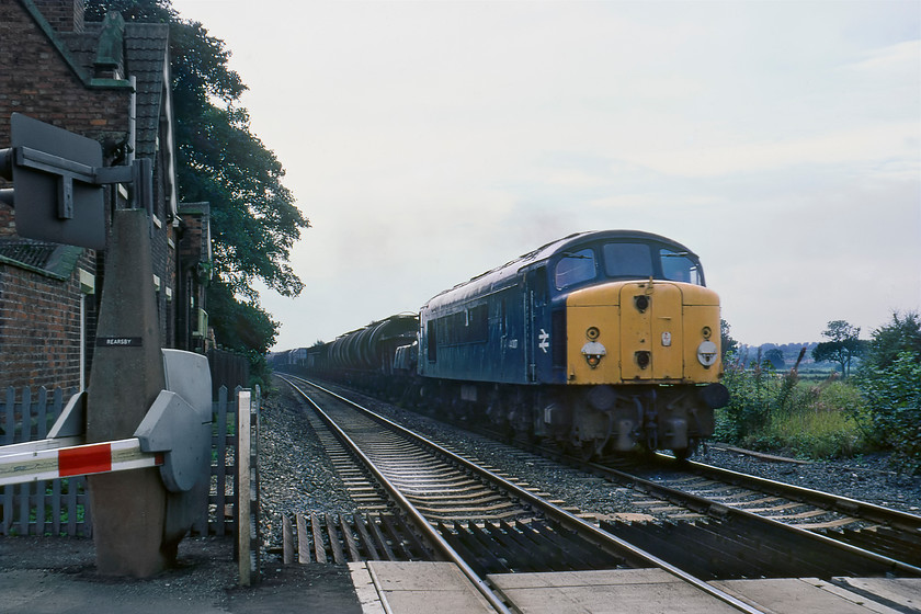 44007, down freight, Rearsby level crossing 
 As we were taking lunch in a pull-in at Rearsby the AHBs were lowered and we got ready for a train. We were delighted as 44007 'Ingleborough' came into view leading a fantastic mixed fitted freight heading in the Peterborough direction. If anybody can identify what this freight may have been please do get in contact. Notice that the Peak, that had just four months left in service, has lost two of its headcode disks perhaps to trophy hunters? In the days before CCTV I was able to step past the marked lines towards the track without causing unnecessary apoplexy to somebody monitoring the crossing at their distant workstation somewhere! 
 Keywords: 44007 down freight Rearsby level crossing Ingleborough