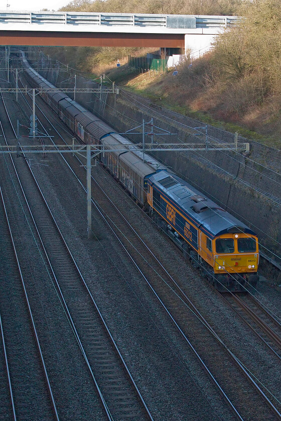 66312, 14.40 DIRFT-Dollands Moor (6O55, 10L), Roade cutting 
 A photographic cop made this short afternoon walk all the worthwhile! The daily empty water train slogs through Roade cutting hauled by recently named (November 2024) GBRf's 66312 'Nigel Harris' (of former Rail fame). It is not actually too surprising that 66312 has evaded my camera all these years as it has spent all of its life in Europe owned and run by a number of operators in a variety of countries. 
 Keywords: 66312 14.40 DIRFT-Dollands Moor 6O55 Roade cutting GBRf Nigel Harris