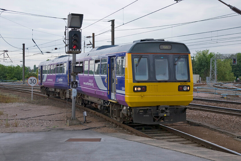 142091, NT 15.29 Leeds-York (2C42), York station 
 Pacer action at the northern end of York station. No doubt with some flange squeal as it takes the curve, 142091 arrives with the Northern 12.59 service from Leeds that has made the journey anticlockwise via Harrogate. 
 Keywords: 142091 15.29 Leeds-York 2C42 York station NT Northern Trains Pacer