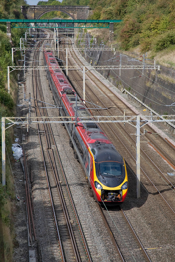 390006, VT 12.50 Birmingham New Street-London Euston (1B24), Roade cutting 
 With its coupling cover missing or tucked away exposing the Dellner mechanicals 390006 'Tate Liverpool' rushes through Roade cutting forming the 12.50 Birmingham to Euston Virgin service. 
 Keywords: 390006 12.50 Birmingham New Street-London Euston 1B24 Roade cutting Virgin Weest Coast Pendolino Tate Liverpool