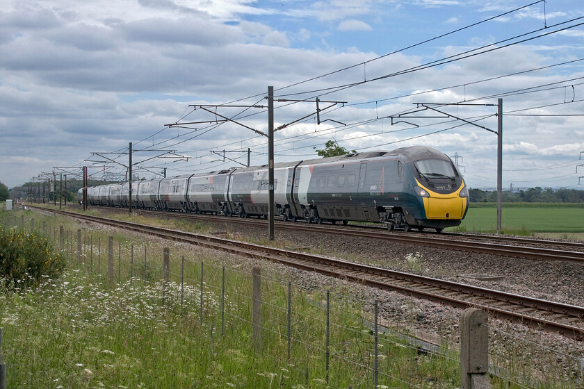 390153, VT 09.10 London Euston-Glasgow Central (1S48, 12L), Mossband M6 bridge NY347654 
 Passing Mossband just a mile or so south of the Scottish border 390153 heads north working the 08.43 Euston to Edinburgh Avanti service. What a delight it is to be able to take unrestricted photographs without the limitations and intrusion of palisade fencing! Despite this rural setting, I am standing directly in front of a vast concrete viaduct that carries the M6 motorway over the railway. 
 Keywords: 390112 08.43 London Euston-Edinburgh Waverley 9S54 Mossband M6 bridge NY347654.