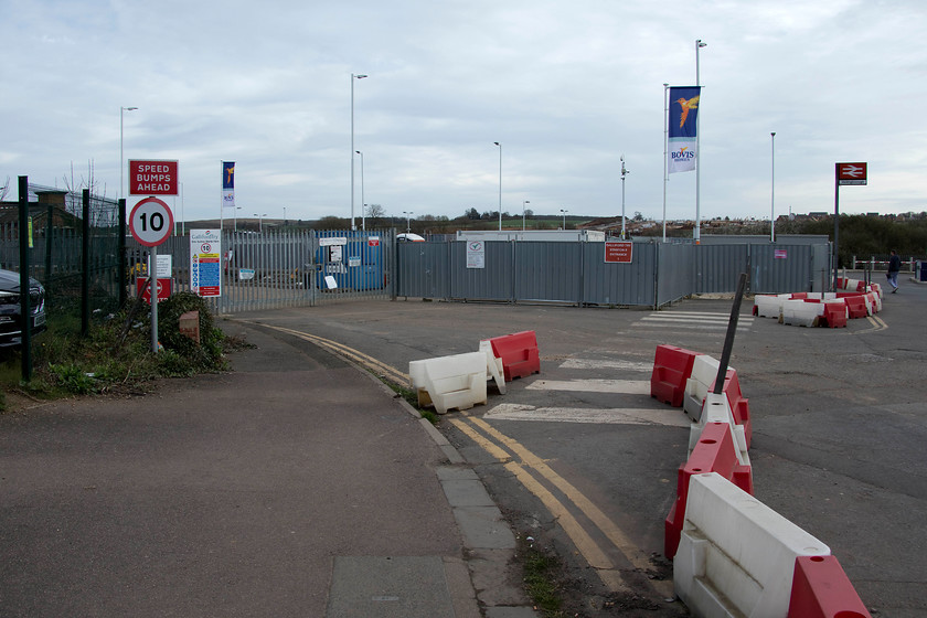 Former station entrance road, Wellingborough station 
 The road off to the left in this picture was the old entrance road down to Wellingborough station. The new entrance road is a much reduced affair beyond the fencing where the man is walking. The old entrance will soon become part of the road linking this part of the town to the huge new Stanton Cross development to the east of the town. An enormous new bridge has been built just north of the station to carry the link road. 
 Keywords: Former station entrance road Wellingborough station