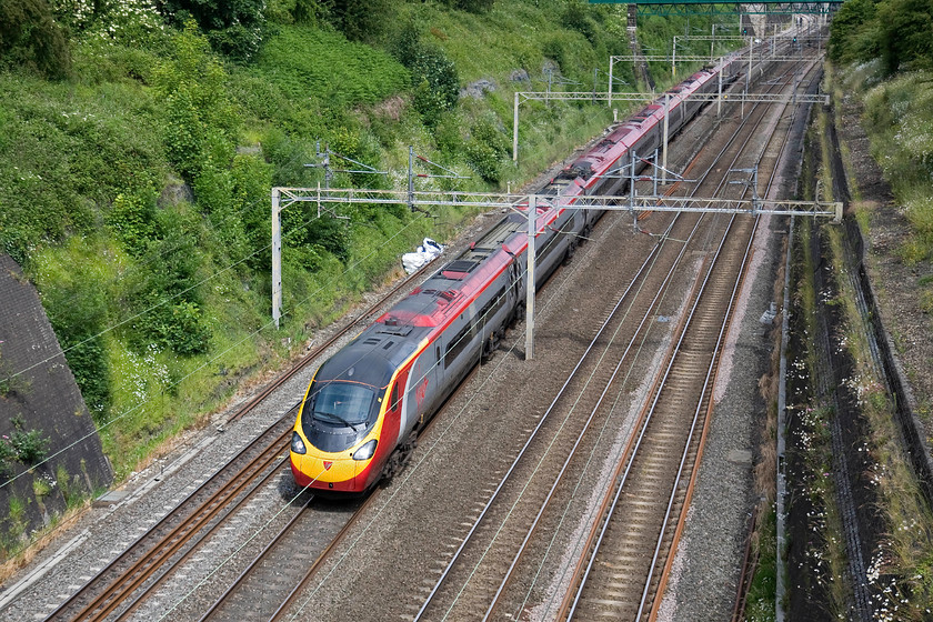 390040, VT 09.15 Manchester Piccadilly-London Euston (1A17), Roade cutting 
 390040 heads south through Roade cutting in the summer sunshine working the 09.15 Manchester Piccadilly to Euston. 
 Keywords: 390040 09.15 Manchester Piccadilly-London Euston 1A17 Roade cutting Virgin West Coast Pendolino