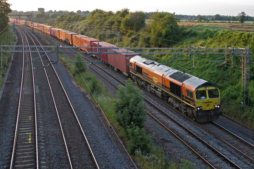 66415, 18.55 Lawley Street-London Gateway (4L51, 1L), Victoria bridge 
 66415 'You Are Never Alone' leads the 18.55 Lawley Street to London Gateway Freightliner past Victoria bridge just south of Roade. It is 20.45 on the day after the longest day and the sun is still just managing to illuminate the side of the train with its warm evening light. 
 Keywords: 66415 18.55 Lawley Street-London Gateway 4L51 Victoria bridge You Are Never Alone Freightliner