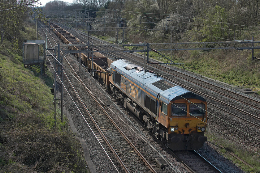 66735, 09.13 Kings Langley-Bescot (6G50, 25L), Victoria bridge 
 If the 09.13 Kings Langley to Bescot engineering train had been on time I would have chosen a different location to capture it but as it was over an hour late I had to make the best of a bad thing with the sun now having come right round. 66735 'Peterborough United' is seen hauling the train composed of a rake of loaded JNA and MLA wagons past Victoria bridge between Roade and Ashton. 
 Keywords: 66735 09.13 Kings Langley-Bescot 6G50 Victoria bridge Peterborough United