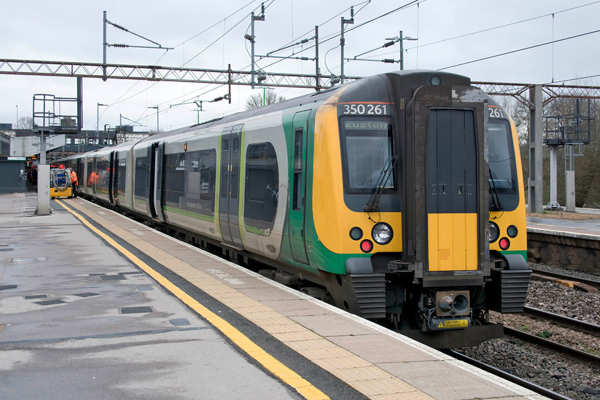 350261, LN 08.33 Birmingham New Street-London Euston (1W06, 6L), Northampton station 
 Our train to London from Northampton stands at platform one. Close examination reveals that a member of staff is watering 350261 that was surprisingly empty considering it was the end of the half-term holiday week. 
 Keywords: 350261 08.33 Birmingham New Street-London Euston 1W06 Northampton station London North Western Desiro