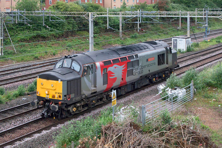 37800, 06.10 Leicester LIP-Ilford EMUD-(0Z, 9E), site of Roade station 
 I stopped off on the way to work to get a photograph of 37800 'Cassiopeia' as it passes Roade running light engine from its Leicester base to Ilford EMU depot. Rail Operation Group has almost cornered the market when it comes to the logistical movement of stock around the country. Its use of heritage diesels brings interest to our rather humdrum railway and I always make the effort to get out and capture its workings. 
 Keywords: 37800 06.10 Leicester LIP-Ilford EMUD site of Roade station Cassiopeia Ril Operation Group ROG Europheonix