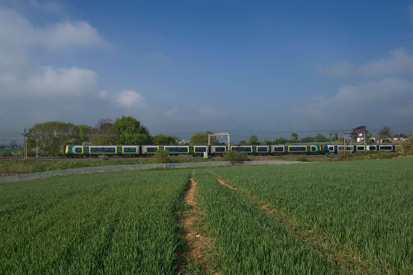 Class 350s, LN 09.15 Northampton-London Euston (2N24, 4L), between Roade & Ashton 
 Class 350 Desiros pass between Roade and Ashton working the 09.15 Northampton to Euston service. I like the way that the tram line in the field of winter wheat that has survived the incredibly wet winter draws the attention to the subject of the photograph. I also like the impressive skyscape that only half an hour earlier had been obliterated by mist and fog. 
 Keywords: Class 350s 09.15 Northampton-London Euston 2N24 between Roade & Ashton London North Western Desiro