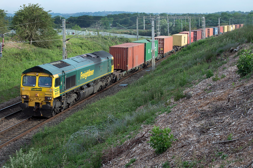 66526, 03.25 Garston-London Gateway (4L52), Milton Malsor SP738560 
 66526 'Driver Steve Dunn (George)' leads the 03.25 Garston to London Gateway Freightliner past Milton Malsor. The train was going incredibly slowly at this point, on the steady 1:200 rising gradient out of Northampton. This location looks idyllically rural but looks can be deceiving. Just across the field to my right is the busy M1 motorway that the rear wagons of the train will be crossing just around the curve and out of view in the distance. 
 Keywords: 66526 03.25 Garston-London Gateway 4L52 Milton Malsor SP738560