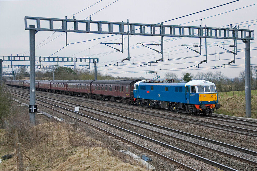 86259, outward leg of The Winter Cumbrian Mountain Express 2, 07.06 London Euston-Carlisle (1Z86), Ashton Road bridge 
 If it's a Saturday morning in February, it must be a Winter Cumbrian Mountain Express charter! As usual, 86259 'Les Ross/Peter Pan' leads the 1Z86 charter between Roade and Ashton that left Euston, as usual, at 07.06. On arrival at Carnforth 60009 'Union of South Africa' took over and led the train to Carlisle where the locomotive was turned on the triangle for it to lead south again over the Settle and Carlisle as far as Farington Junction where 86259 again took over to bring the train back to Euston in the evening. 
 Keywords: 86259 The Winter Cumbrian Mountain Express 07.06 London Euston-Carlisle 1Z86 Ashton Road bridge Les Ross Peter Pan