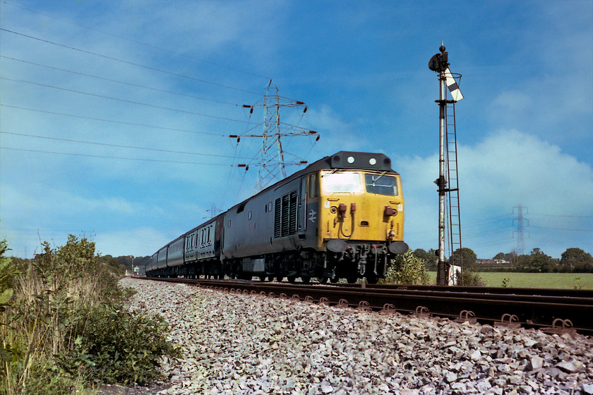 50008, 12.23 London Paddington-Paignton (1B74), Berkely Down ST793482 
 When I took this picture at Berkely Down near Frome I was so proud of it! I thought that the low angle shot really showed off the speed of 50008 Thunderer powering 1B74 12.23 London Paddington to Paignton. However, how did I not spot the huge transmission tower growing out of the 50s roof? With the marvels of Photoshop I could clone it out but I feel that I want to keep it in its as taken state. In the background, Clink Road Junction signal box can be made out that controls the home signal that the 50 is about to pass. 
 Keywords: 50008 12.23 London Paddington-Paignton 1B74 Berkely Down ST793482