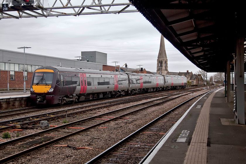 170101, XC 10.10 Nottingham-Cardiff C (1V07, 5L), Gloucester station 
 With the spire of St. Peter's Church dominating the background at Gloucester station Cross Country 170101 leaves, forming the 10.10 Nottingham to Cardiff Central. Whilst these 1998 Derby built units have been a success, I still struggle to understand how passengers can make a long inter-regional journey, such as this working, in comfort. 
 Keywords: 170101 1V07 Gloucester station