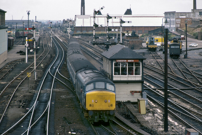 45104, 12.10 Sheffield-London St. Pancras (1M21), Leicester North 
 This well-known view of Leicester North is taken from the bridge that carries Swain Street over the railway. In this scene 45104 'Royal Warwickshire Regiment' slows for its stop at Leicester station leading the 1M21 12.10 Sheffield to St. Pancras service. The train is passing the 1911 Midland-built Leicester North signal box and some of its associated signalling. The superb three-doll bracket signal just beyond the box is notable as is the relatively empty PW yard to the right. 
 Keywords: 45104 12.10 Sheffield-London St. Pancras 1M21 Leicester North Peak Royal Warwickshire Regiment