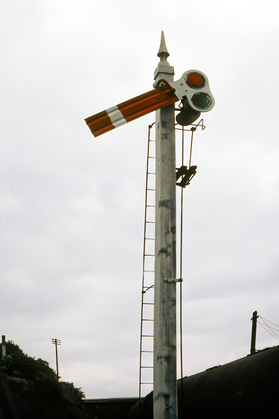 Former Midland Railway lower quadrant signal, Leicester yard 
 I am not at all sure how we got into Leicester yard to take this photograph but my contemporary notes describe how we managed to get to the signal in some detail! My words say how we slowly walked along a path next to the lines in the shadow of a slow-moving tanker train, that can be seen behind the signal, thus hiding us from the station and the signalman in North box. While I do not condone these actions some forty years on I am really pleased that this photograph was the result. It shows a very rare ex-Midland lower quadrant semaphore that was still in use mounted on an original wooden post complete with a very ornate finial. Even back in 1980, this pre-grouping piece of operational infrastructure was at least sixty years old but probably considerably more. 
 Keywords: Former Midland Railway lower quadrant signal Leicester yard