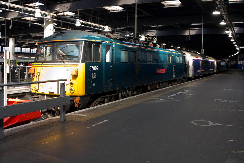 87002, CS 20.26 Inverness 21.43 Aberdeen 19.00 Fort William-London Euston sleeper via ECML (1M16, 6E), London Euston station 
 As we had arrived earlier than normal into Euston the sleeper stock was still sitting in platform 1. 87002 'Royal Sovereign' sits on the blocks at Euston with the stock of the Caledonian Sleeper but looks can be deceiving. Passengers did not enjoy this classic haulage all the way from Scotland but only from Wembley Yard! This was because the sleeper had travelled via the ECML the previous night due to engineering works. From the ECML it then traversed the North London Line to Wembley facing north then to be drawn back in to Euston, hence 87002 on the city end of the stock. 
 Keywords: 87002 sleeper 1M16 London Euston station