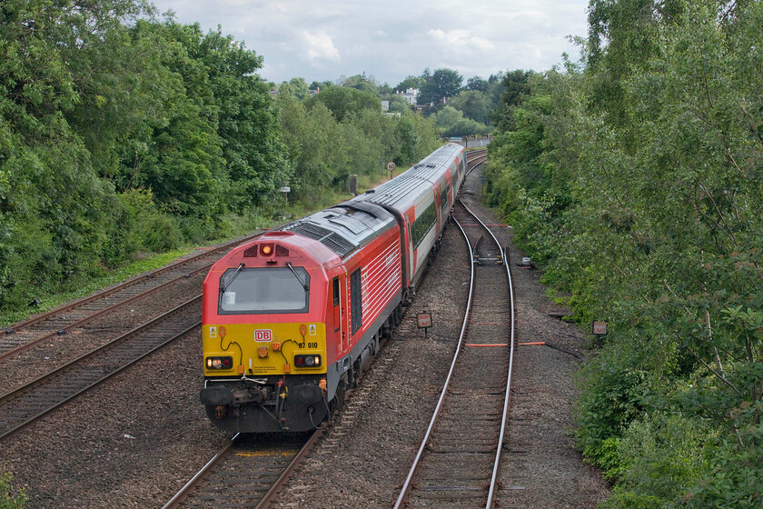 67010 AW 16.36 Holyhead-Cardiff Central (1V98, RT), Bonewaldesthorne's Tower Chester city wall 
 With the dramatic growth of trees to the west of Chester, the previous views of the grand Roodee Viaduct have been lost from this location atop the city walls. Towards the rear of the train, the parapets of the viaduct can just be seen. Transport for Wales' 67010 approaches the city with the 16.36 Holyhead to Cardiff Central 1V98 service. The stock is a rake of former LNER Mk. IVs that still carry their old livery minus the branding that is a remarkable match to the TFW paint scheme! 
 Keywords: 67010 16.36 Holyhead-Cardiff Central 1V98 Bonewaldesthorne's Tower Chester city wall