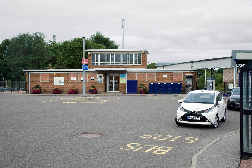 Frontage, Forres station 
 Our new hire car stands in the forecourt of Forres station. The rather utilitarian structure was opened in 1955 by British Railways replacing the original structure. When I last visited in 1984 I took a very similar view to this, but rather than a Toyota Aygo in the car park there was a Renault 18 taxi! Plans have been just been announced for a brand new station at Forres and major track realignment removing the curved section of track in and out of the present station. This plan will also lead to the closure of the signal box a short distance to the east of the station. 
 Keywords: Frontage, Forres station